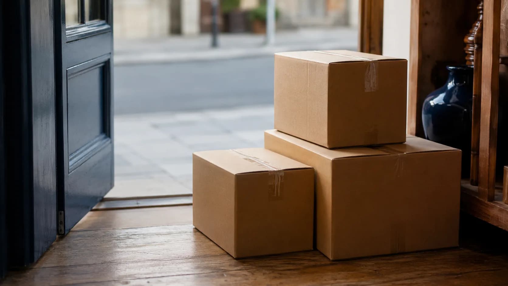 Cartons scellés fraîchement livrés, posés juste à l'entrée d'une boutique.