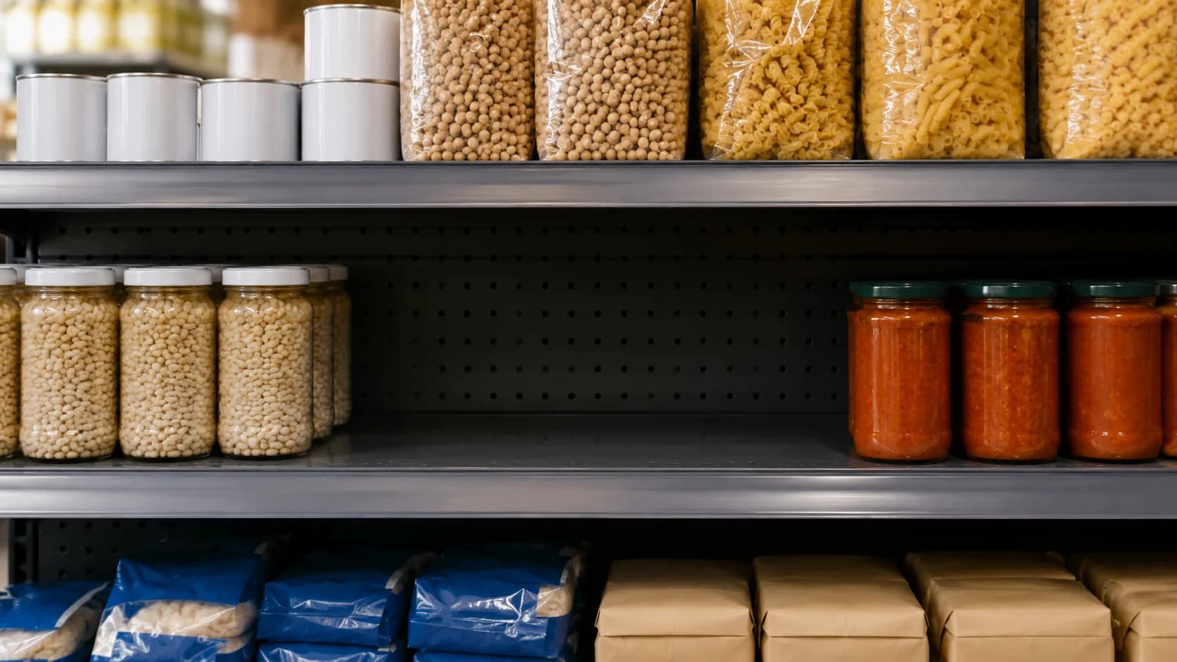 Un rayon d'épicerie photographié de face, avec deux emplacements vides au milieu des produits.